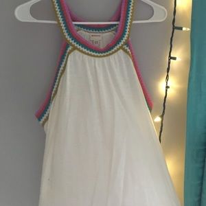 a white shirt with colorful straps and on the side